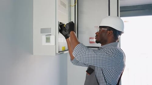 African American Electrician Worker Checking Repair Maintenance Operation Electric System in Office