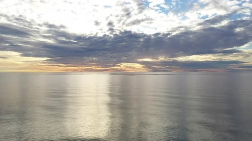 LUFTAUFNAHME: Panoramaaufnahme des Fliegens über der Ostsee während der Goldenen Stunde mit majestätischem Horizont mit Orange und