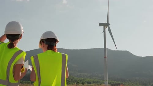 As Energy Researchers Two Women Engineers Analyze and Compare Data on a Clean Wind Farm with