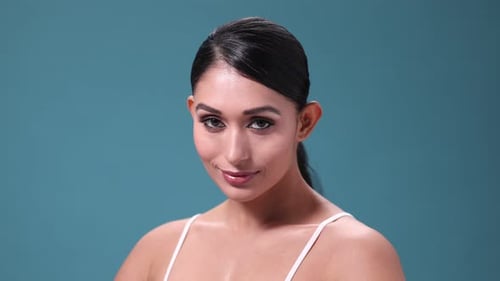 Woman smiles during beauty shot with hair pulled back
