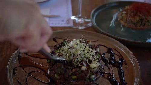 Hands Cut Appetizing Beef Tartare Dish at Restaurant