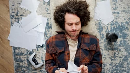 Young Adult Lying Down and Taking Notes