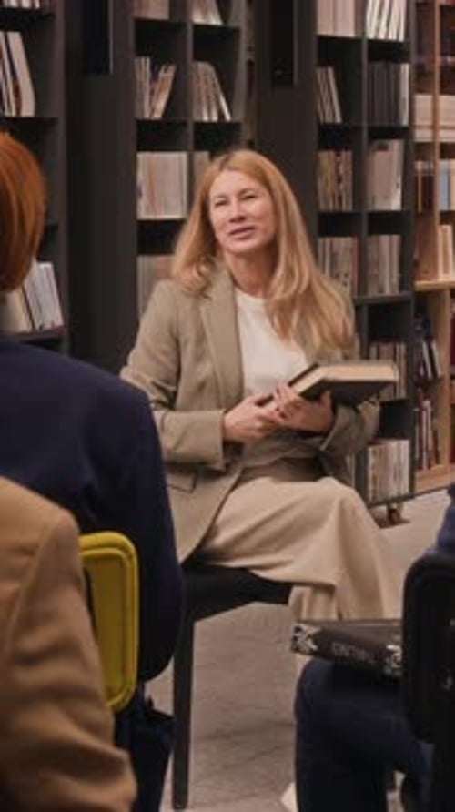 Audience Raising Hands After Author Finishing Reading In Library