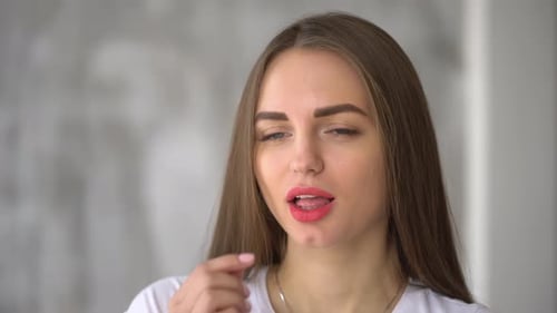 Woman Takes Pill and Drinks Water in Kitchen