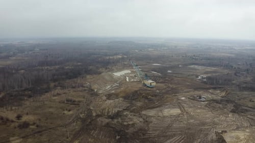 Dragline excavator works in an open pit for the extraction of clay.