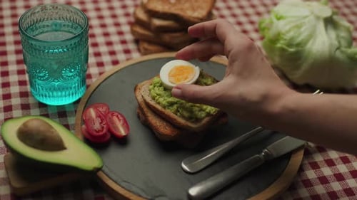 Adding Egg Slice to Avocado Toast for Breakfast