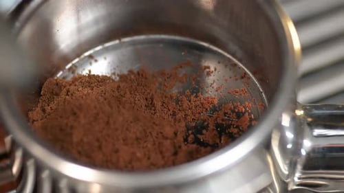 Freshly ground coffee beans, coffee grinding process close-up