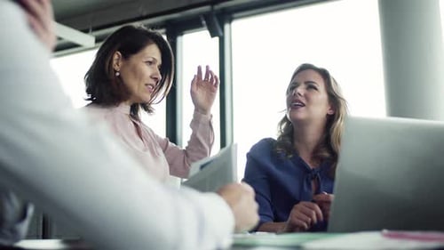 Empresários alegres colaborando e discutindo ideias em um escritório moderno