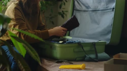 Woman Packing Suitcase with Clothing for Vacation
