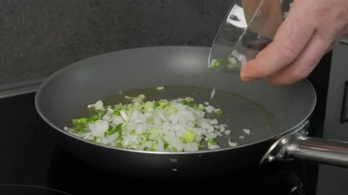 Chopped Onion being Added to Hot Frying Pan