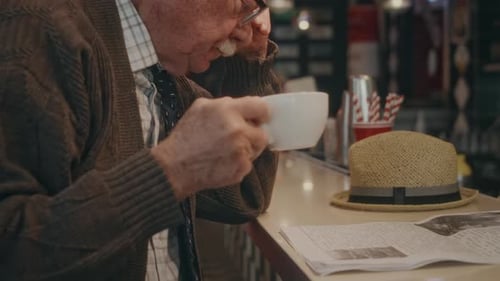 Senior Man Reading Newspaper with Coffee at Diner