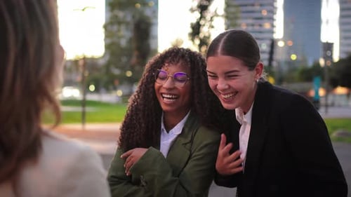 Three Young Women Laughing Together in Urban Setting