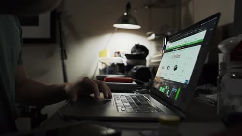 Man taking a break and drinking water while shopping on his laptop
