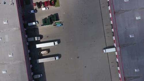 High-Angle View of Semi Trucks Docking at a Large Logistics Warehouse