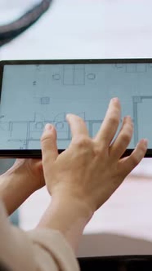 Vertical Video Real Estate Agent Evaluating Blueprints and Discussing the Architectural Layout