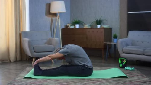 Mature Man Stretching on Exercise Mat Indoors