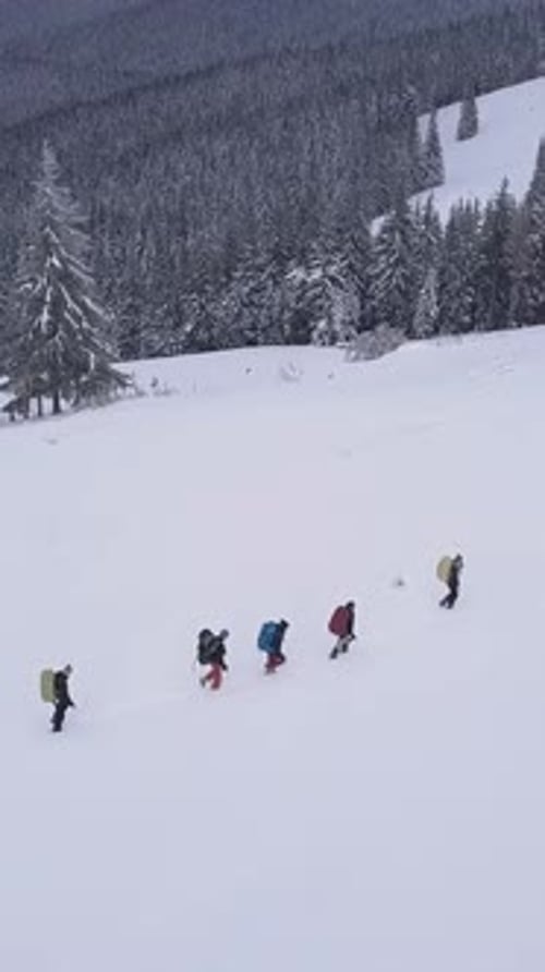 Überfliegen einer Touristengruppe mit Rucksäcken in den Winterbergen