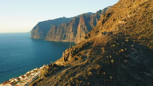 Hiker on Edge of Rock Looking on Ocean