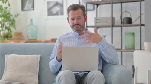 Man on Couch Video Calling with Laptop