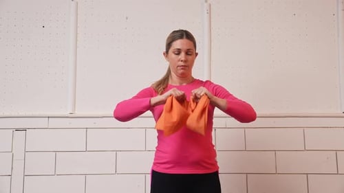 Woman Exercises with Orange Resistance Band at Home