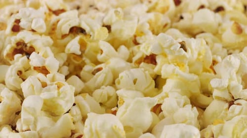 Rotating popcorn grains. Popcorn background. Macro and close-up.