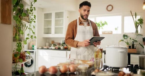 Man Uses Tablet for Recipe in Bright Kitchen