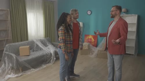 A Realtor Talks About the Benefits of an Apartment to a Couple A Couple Shaking Hands with a Realtor