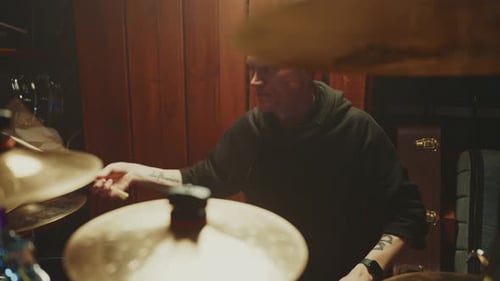 Drummer Practices Intense Rhythm in Dimly Lit Studio During Late Night Session