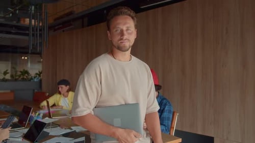 Young Adult Man with Laptop in Modern Office