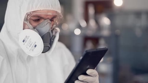 Scientist in Hazmat Suit Using Tablet in Lab