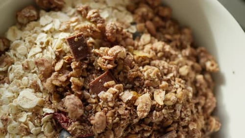 Close-up of a breakfast bowl with granola, and berries on a table.