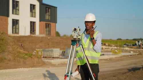 Surveyor Engineer Using Theodolite on Construction Site