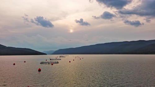 Fishing Cages for Breeding Fish in Lake in Mountain Valley of Rhodope Mountains Under Cloudy Sky