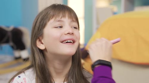 Child Having Makeup Applied to Face by Adult