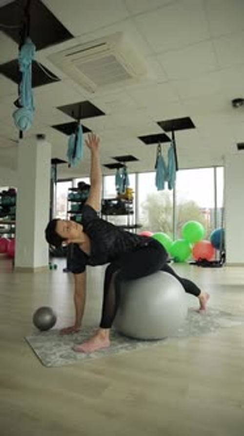 Woman Doing Yoga Stretch with Exercise Ball