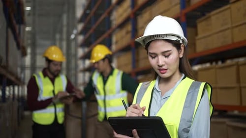 Blue collar workers are working at warehouse.