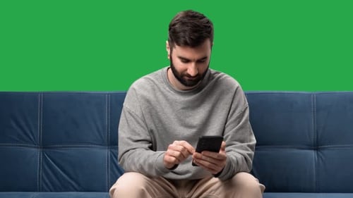 Lächelnder Mann, der auf dem Smartphone chattet, soziales Netzwerk, Surfen im Internet, isolierter grüner Bildschirm, Chroma-Taste
