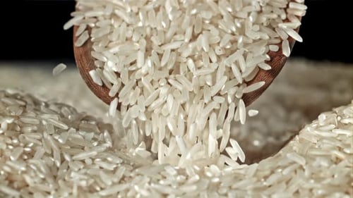 Rice Grains Pour Out of the Scoop, gefilmt mit einer Hochgeschwindigkeitskamera mit 1000 Bildern pro Sekunde