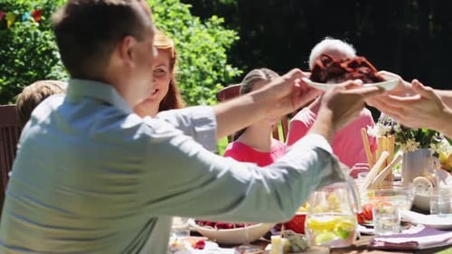 Family gathers at outdoor table for food and celebration