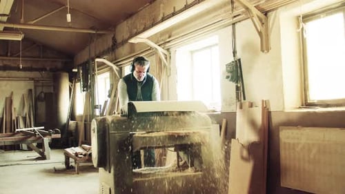 A Man Worker in the Carpentry Workshop, Working with Wood