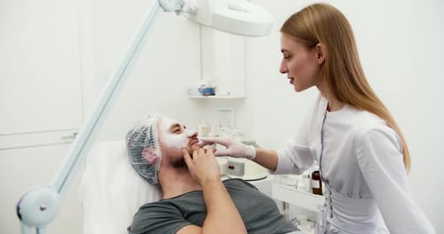 Doctor Consults with Patient Receiving Facial Mask