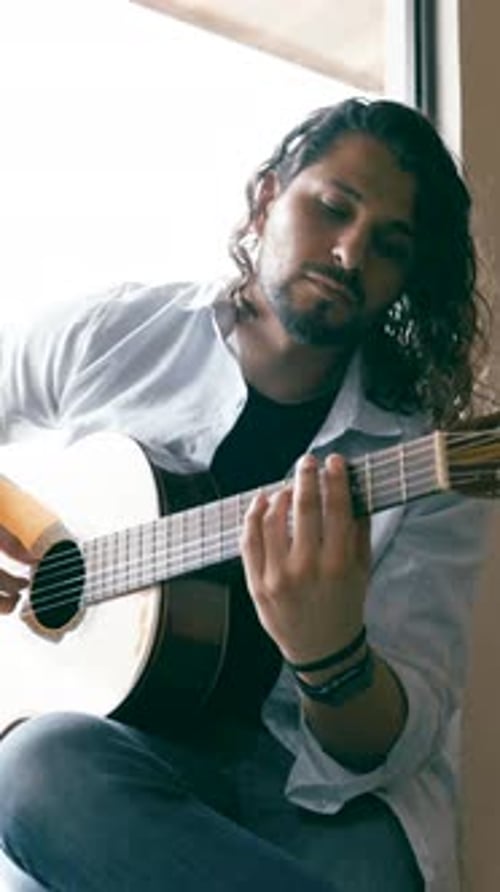 Passionate Guitarist Playing Acoustic Guitar at Home