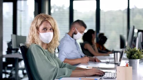 Business professionals wearing face masks in the office during coronavirus pandemic