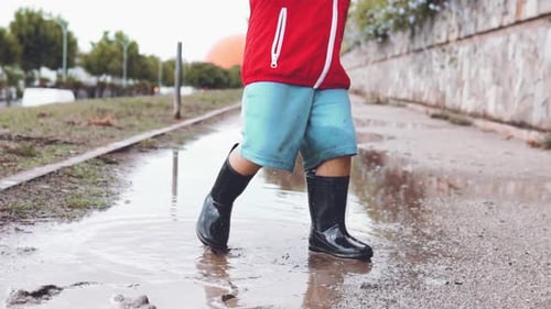 Child Splashing in Puddle on Rainy Day