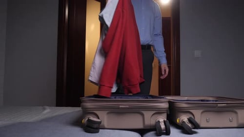 Man Packing Suitcase for Travel in Bedroom