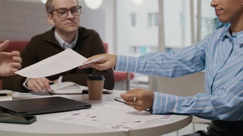 Professionals in Office Meeting Reviewing Documents and Coffee