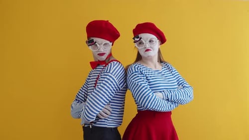 Two Mimes Standing Back to Back with Arms Crossed