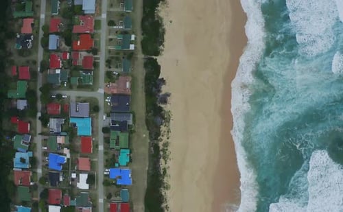 4k drone footage of a coastline alongside a city