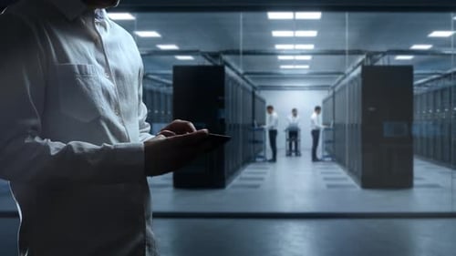 Man Using Tablet in Data Center with Workers
