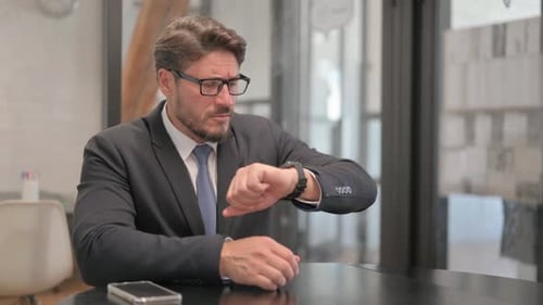 Man Checking Watch While Waiting at Meeting